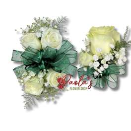 Two white rose corsages with green ribbon bows and baby's breath