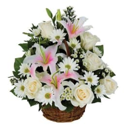 Basket arrangement of white roses, pink lilies, and white daisies