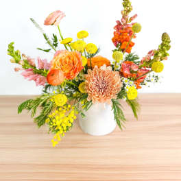 Colorful mixed flower arrangement in a white vase