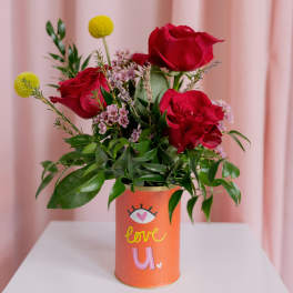 Red roses in an orange can with a love message