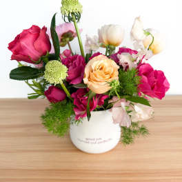 Mixed pink and peach roses in a white mug vase