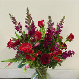 Red and purple mixed bouquet in a clear glass vase