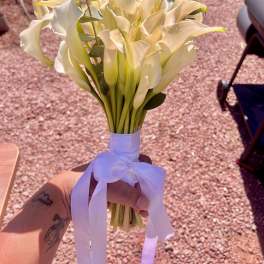 Bouquet of white calla lilies tied with a white ribbon