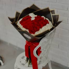 Bouquet of red and white roses wrapped in black paper with a red ribbon
