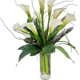 White calla lilies arranged in a clear glass vase