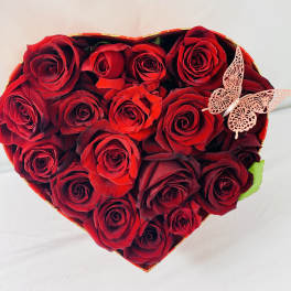 Heart-shaped box of red roses with a butterfly decoration