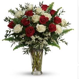Red and white roses in a clear glass vase