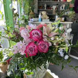 Pink roses and lilies arranged in a clear glass vase
