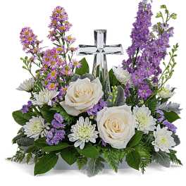 White and purple flower arrangement with a crystal cross in the center