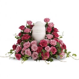 Cremation urn ringed by pink roses and trailing ivy vines