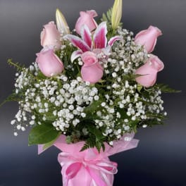 Pink roses and a lily bouquet in pink wrap with ribbon
