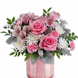 Pink roses and mixed flowers in a pink glass vase