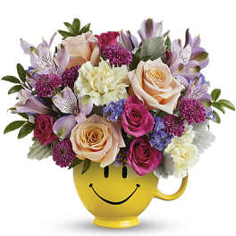 Cheerful mixed bouquet in a yellow smiley-face mug