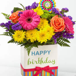 Bright mixed bouquet in a birthday gift box with a colorful topper