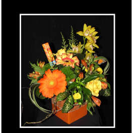Orange and yellow mixed flower arrangement in a square orange box