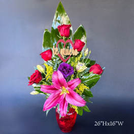 Tall bouquet of pink lilies and red roses in a red vase