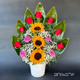 Basket arrangement with red roses, sunflowers, and pink carnations