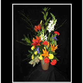 Tall mixed flower arrangement in a brown vase