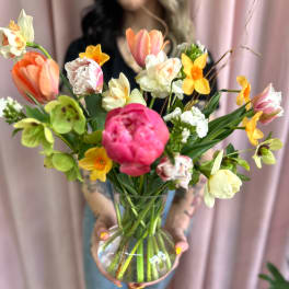 Mixed bouquet of tulips and daffodils in a clear glass vase