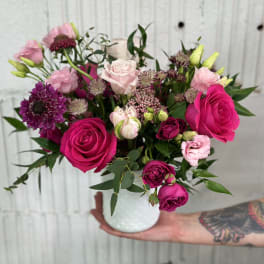 Pink and purple rose bouquet in a white vase