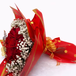 Bouquet of red roses with white baby's breath in red wrapping