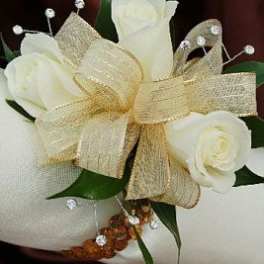 White roses with a gold ribbon bow and rhinestone accents