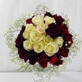 Bouquet of red and cream roses in a clear glass vase