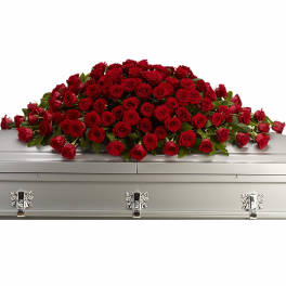 Large blanket of red roses arranged as a casket spray on a closed silver casket