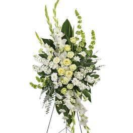 Tall standing spray of white and pale yellow flowers on a metal easel