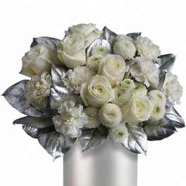 White roses, carnations, and pompom mums with silver leaves in a white cylinder vase