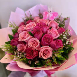 Bouquet of pink and red roses with a butterfly pick