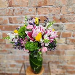 Pink and white bouquet in a green glass vase