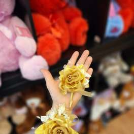Pair of gold floral wrist corsages with white accents