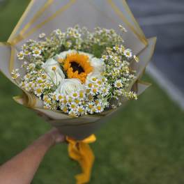 Bouquet of white daisies and roses with a sunflower center
