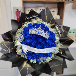 Blue rose bouquet with a silver crown and black wrapping