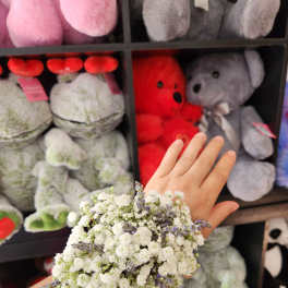 Small white and lavender flower cluster held on a wrist