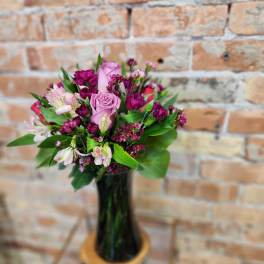 Pink and magenta bouquet in a tall glass vase