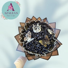 Black decorative bouquet with butterfly accents and a crown topper