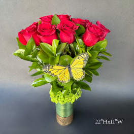 Red roses in a vase with a yellow butterfly accent