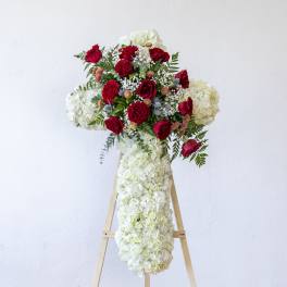 Red roses and white hydrangeas arranged on a standing easel display