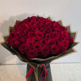 Large bouquet of red roses wrapped in black and gold paper