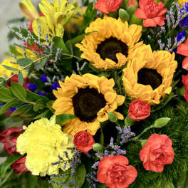 Bright bouquet with sunflowers, red carnations, and yellow blooms
