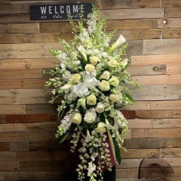 Tall white floral arrangement with roses and calla lilies