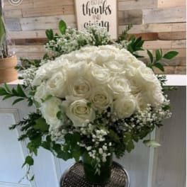 White rose bouquet with baby's breath in a glass vase