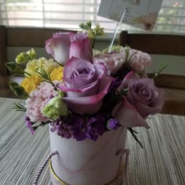 Pink and lavender roses in a round gift box