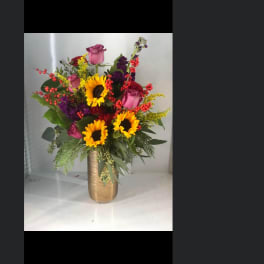 Bouquet of sunflowers and pink roses in a gold vase