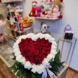 Heart-shaped bouquet of red roses edged with white carnations