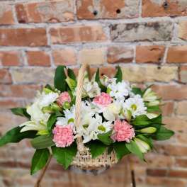 Basket arrangement of white and pink flowers with greenery