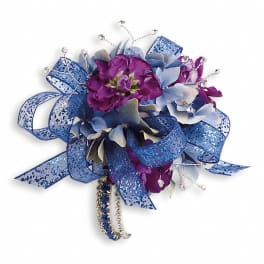Purple and blue floral corsage with glittery ribbon and rhinestone accents