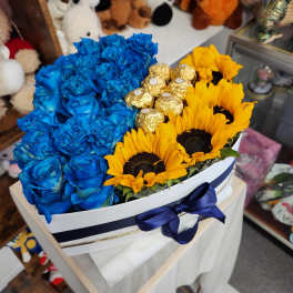 Blue roses and yellow sunflowers in a white hat box with gold chocolates